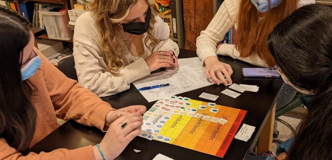 Biology Students playing a board game about antibiotic resistance